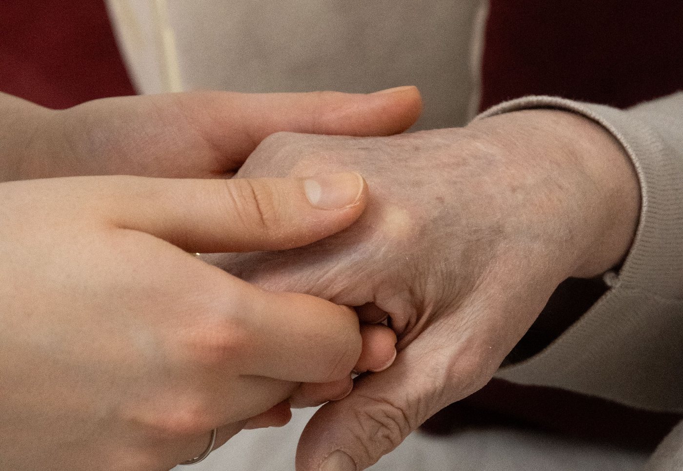 Two hands, one gently holding another